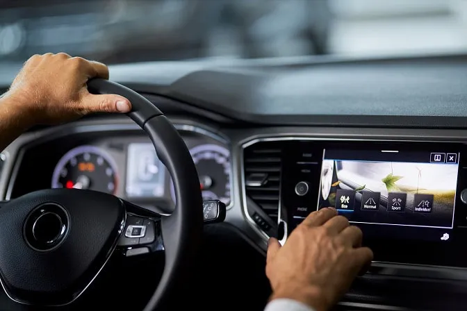 Driver using the factory touchscreen in a car dashboard